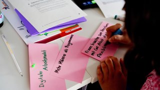 Hand, die mit Edding Thesen zum Thema Gleichstellung auf bunte Karten schreibt.